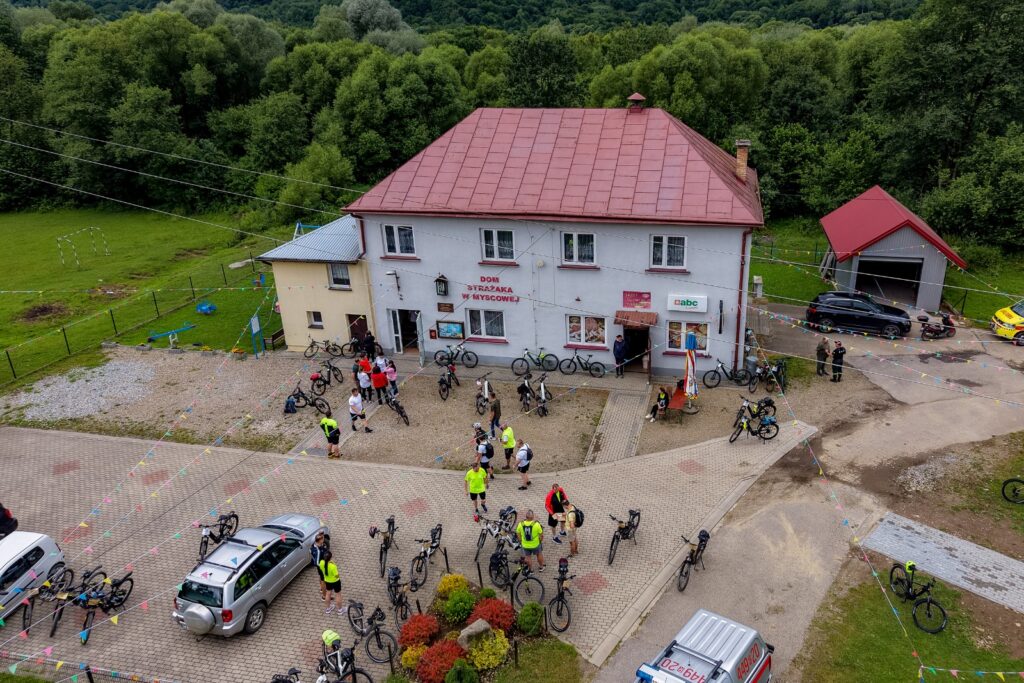 Widok z drona na rowerzystów i rowery przed Domem Strażaka
