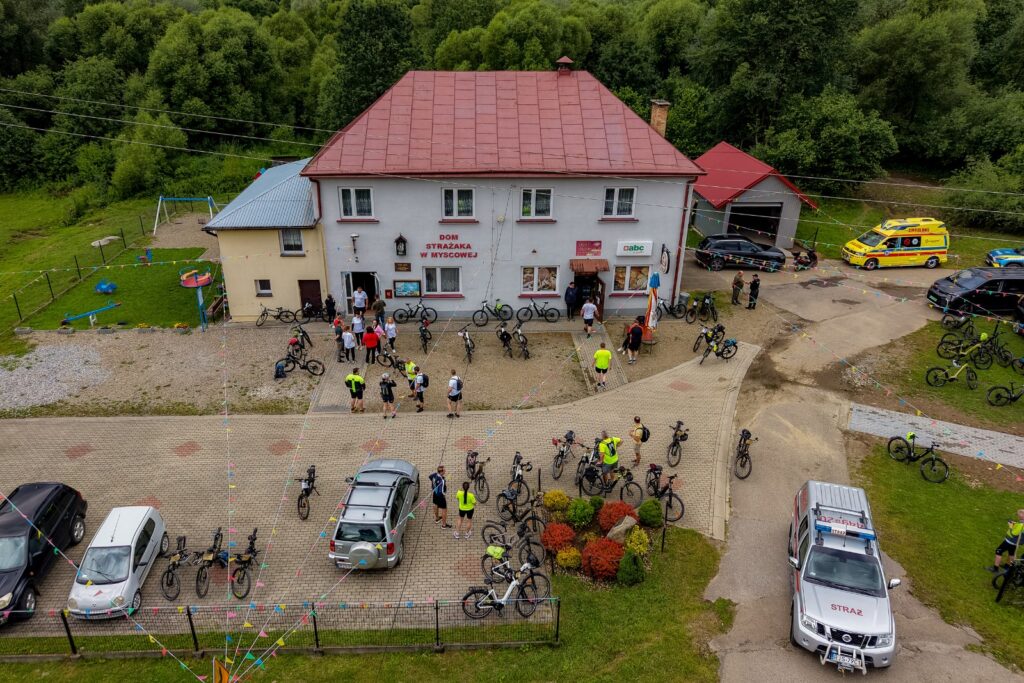 Widok z drona na rowerzystów i rowery przed Domem Strażaka