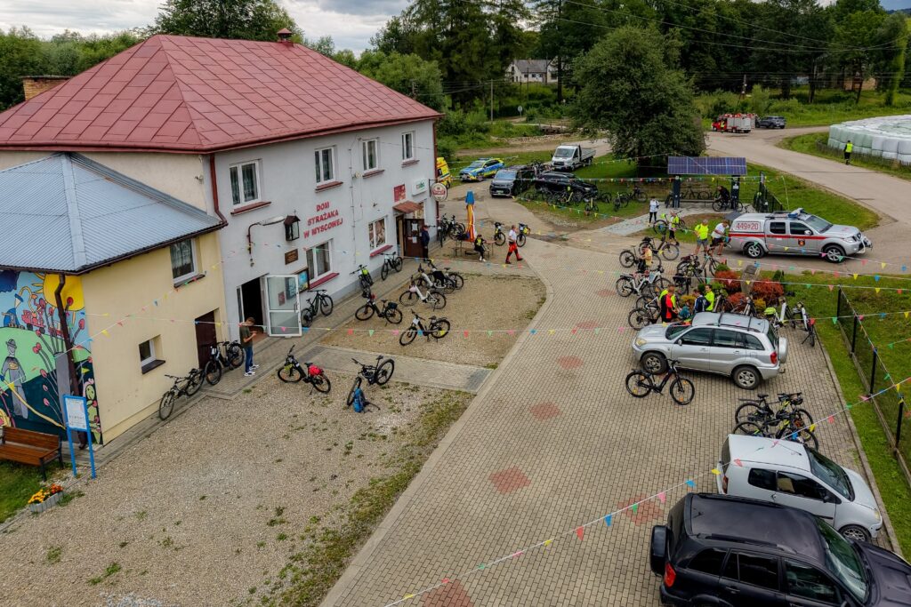 Widok z drona na rowerzystów i rowery przed Domem Strażaka