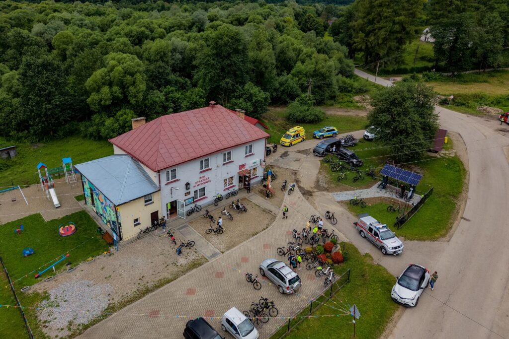 Widok z drona na uczestników rajdu zgromadzonych przy Domu Strażaka