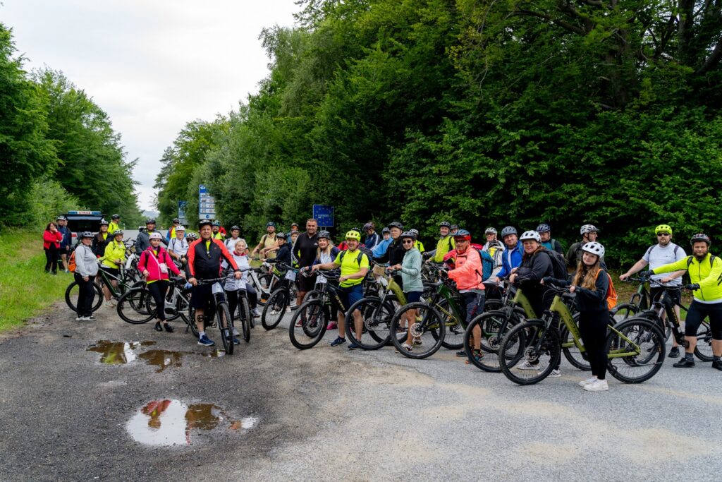 Uczestnicy rajdu rowerowego „Trasami Pogranicza” pozują z rowerami na leśnej drodze