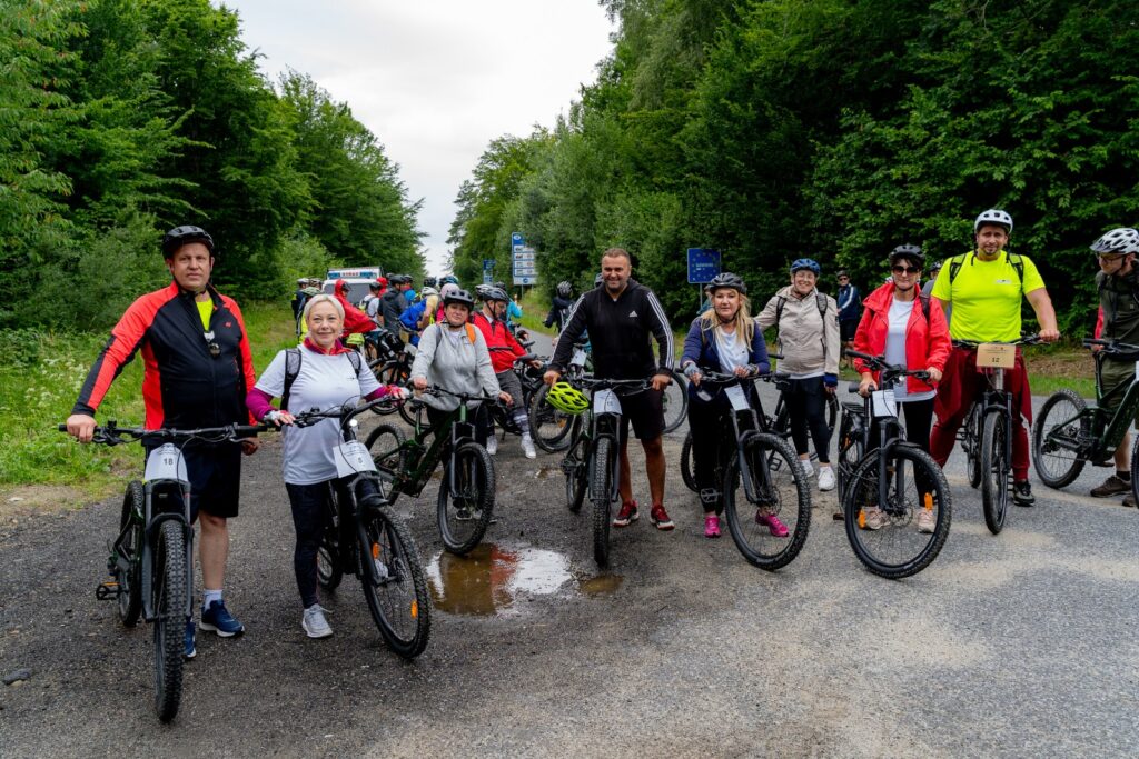 Uczestnicy rajdu rowerowego „Trasami Pogranicza” pozują z rowerami na leśnej drodze