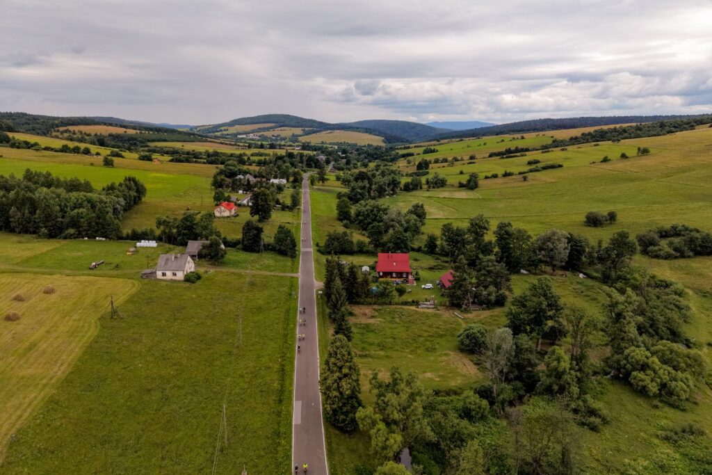 Widok z drona na drogę z jadącymi rowerzystami