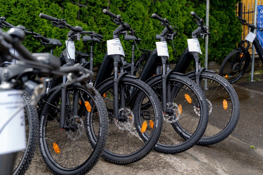 Rowery elektryczne zaparkowane przy krawężniku na parkingu,