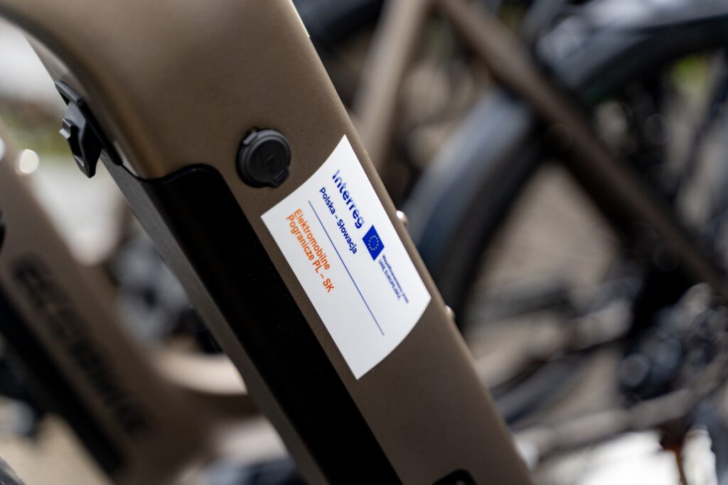 Naklejka na ramie roweru z logo Interreg Polska – Słowacja i napisem „Elektromobilne Pogranicze PL-SK”.
