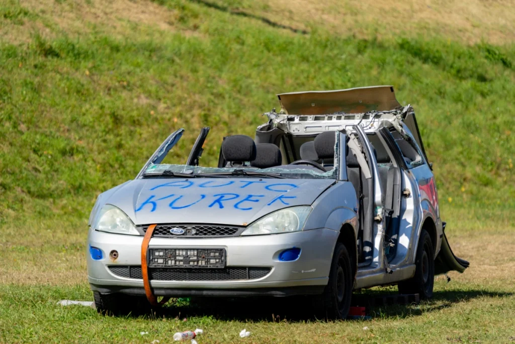 A silver car marked AUTO KUREK after the rescue demonstration, with no roof and its doors bent open